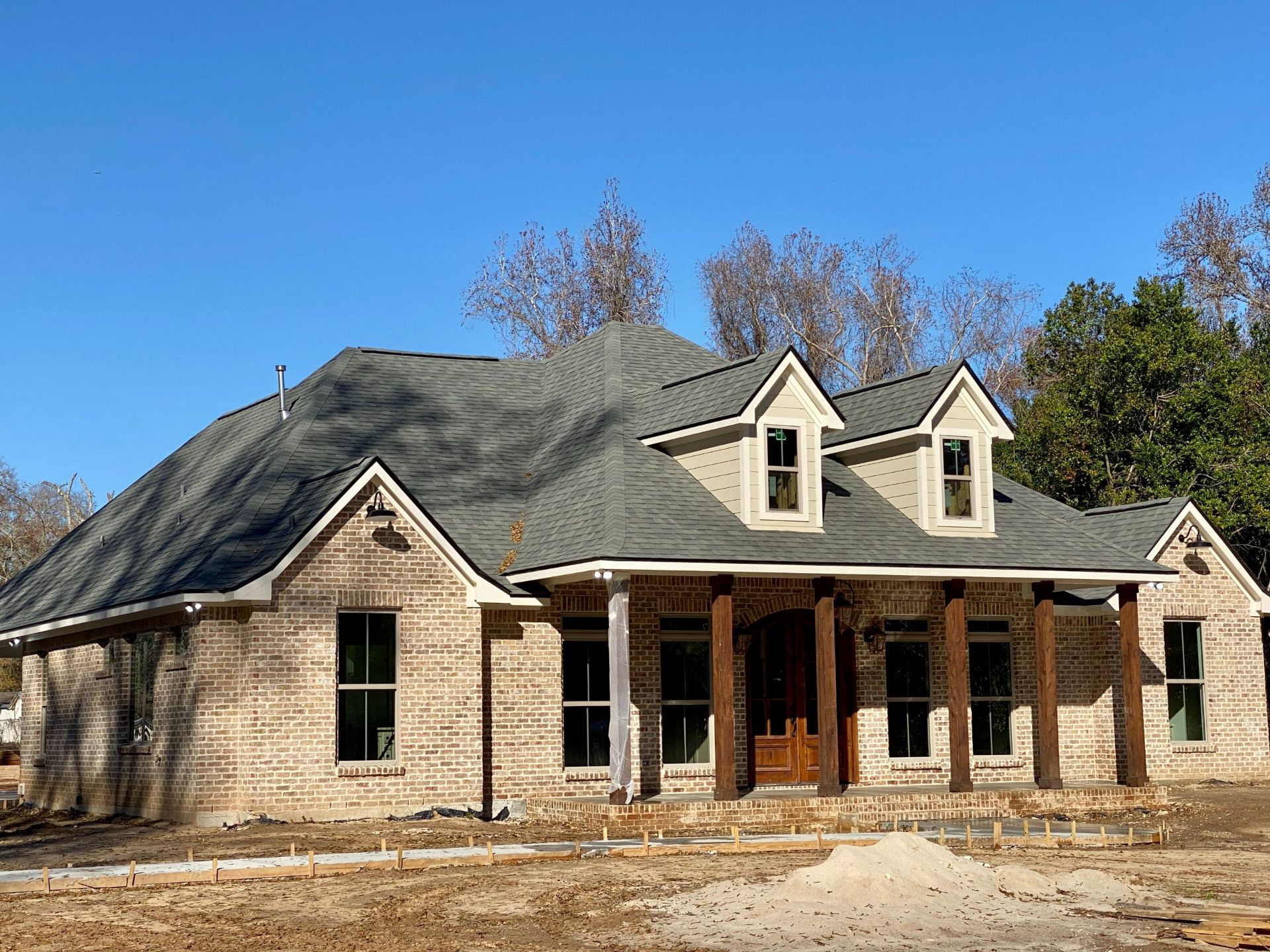 Acadian-Style custom home, reclaimed brick, custom mahogany front doors.